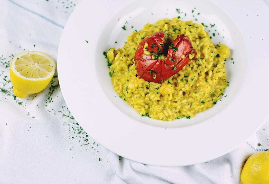 A bowl of jollof risotto topped with roasted tomato