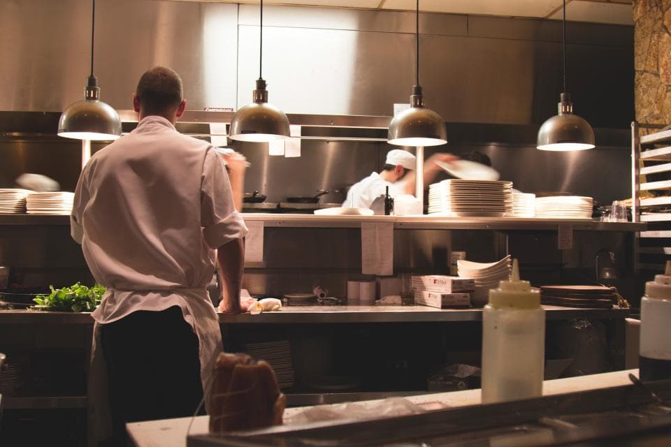 A chef at work on the line in a busy restaurant kitchen