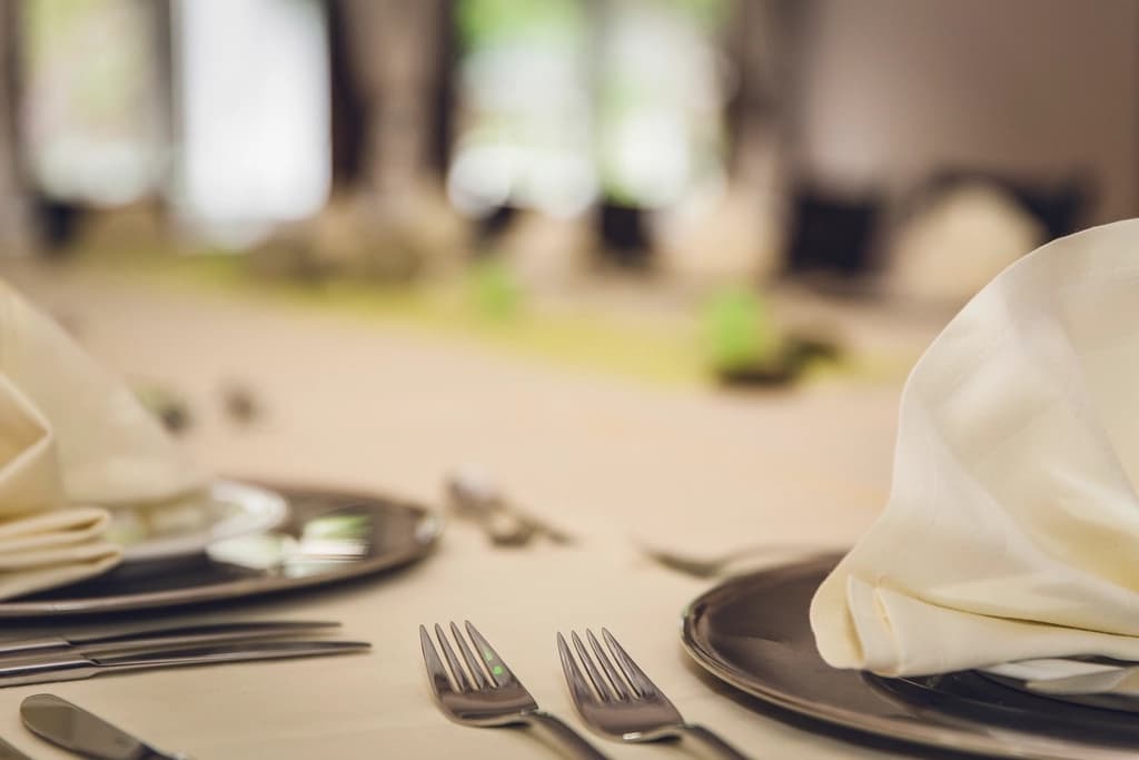 An elegantly set table with folded napkins and polished cutlery